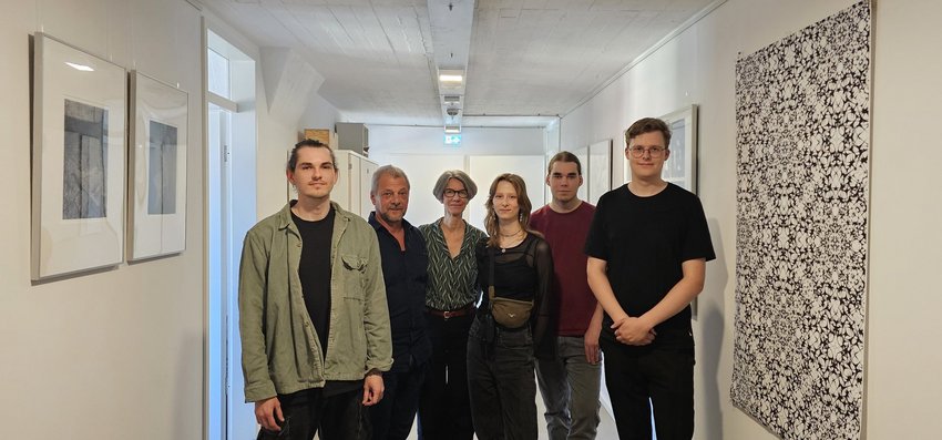 Ein Flur mit vier Menschen und Kunstwerken