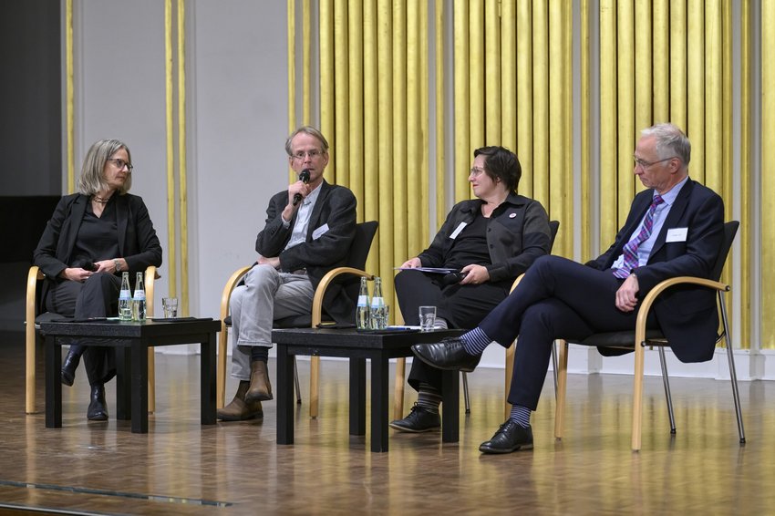 vier Menschen auf einem Podium