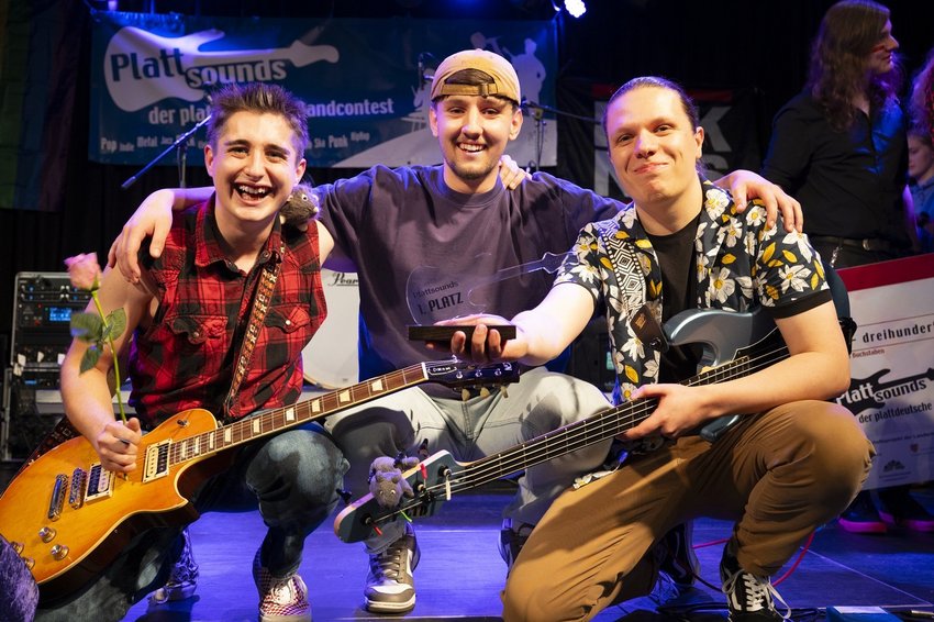 Drei junge Männer mit Musikinstrumenten