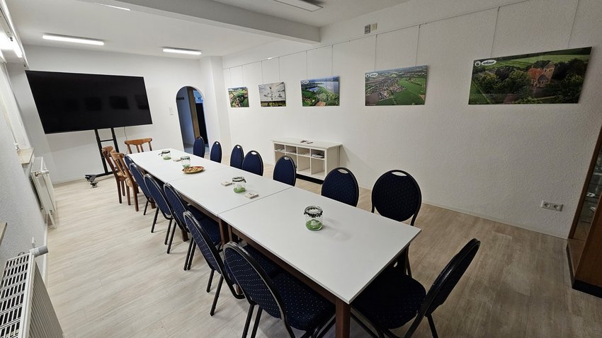 Ein Veranstaltungsraum mit einen großen Tisch und Stühlen